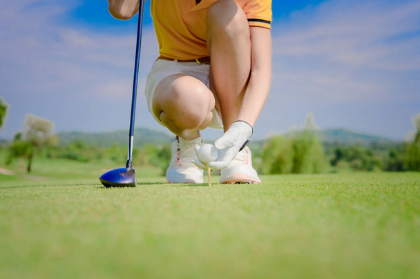 Hand of woman golfer laying golf ball ontoo wooden tee on tee off pin on the golf course, ready to hit ball away to the fairway - Foto, Imagem