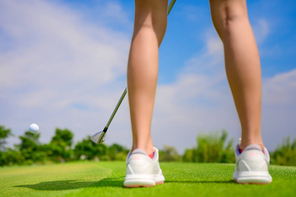 Pitching wedge taking golf ball away from edge of the green to destination hole on the green, final destination for the winner of the woman golfer - Φωτογραφία, εικόνα