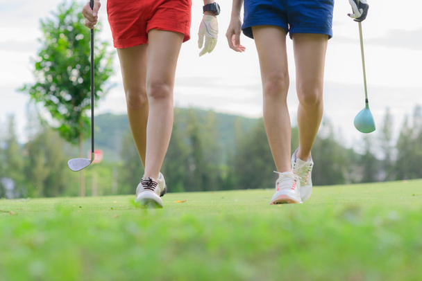 legs of young woman golf players both walking to the fairway after hit the ball from T-OFF, next shot going to takes on the fairway hit to the green - Photo, Image