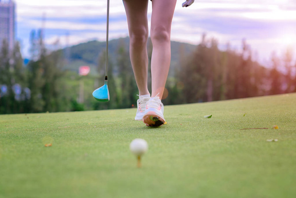 legs of woman golf player walking to hit the golf ball on T-OFF, competitive walking of the golfer - 写真・画像