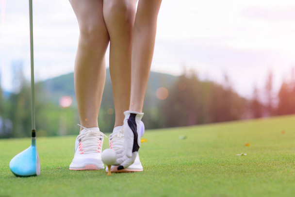 young woman golf player laying golf ball on the wooden tee, prepare and ready to hit the ball away to fairway destination winning - Foto, Imagen