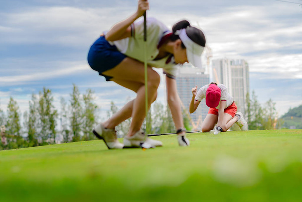 young woman golf player acting upset disaster or disturb or disappointed in golf ball putting successfully into hole by another opponent competito - Φωτογραφία, εικόνα