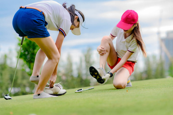 young woman golf player feel uncomfortable in wear of golf shoe, change or replace active shoe in the golf course, dissatisfied golf shoe during playing in golf course - Foto, Imagen