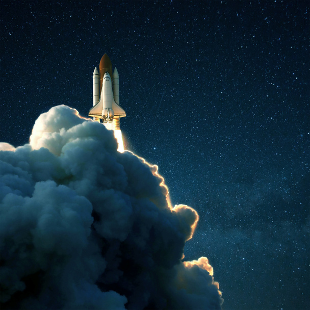 Une fusée spatiale se lance dans l'espace contre un ciel bleu étoilé. Navette avec nuages de fumée
 - Photo, image