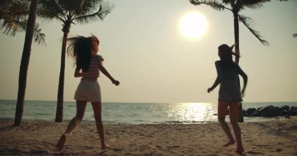 Slow motion: Silhouet jonge vrouwen vrienden genieten van het leven lopen en springen samen op het strand, Aantrekkelijke Aziatische vrouwelijke reiziger mensen levensstijl. 4k Uhd Filmbeelden. - Video