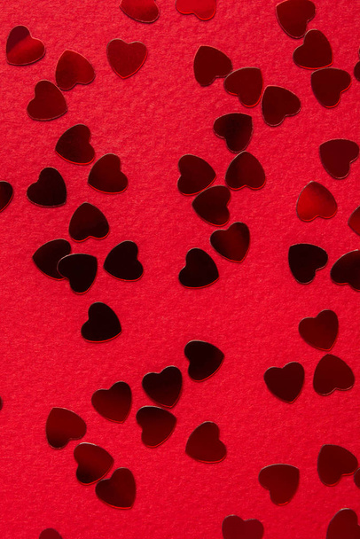 Red heart shape confetti over red background. Top view - 写真・画像