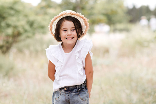 Весела дівчинка 3-4 роки розважається на відкритому повітрі. Носіння літнього одягу
.  - Фото, зображення