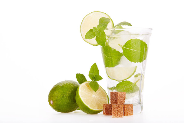 Mojito cocktail with lime, leaves of mint and pieces of sugar on a white background. - 写真・画像