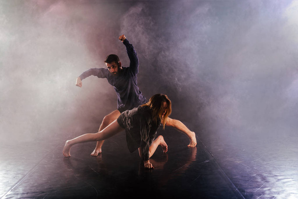 Couple de danse moderne tordant leurs jambes et se léchant près du sol, touchant et combinant leurs corps dans une expérience de danse moderne extrêmement unique
. - Photo, image
