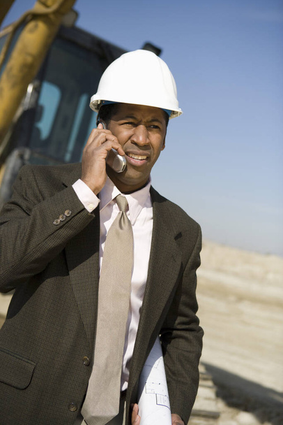 Architect wearing headhat as he's on call at construction site - Φωτογραφία, εικόνα