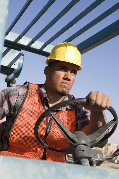 Worker wearing hardhat driving a bulldozer - Foto, Bild