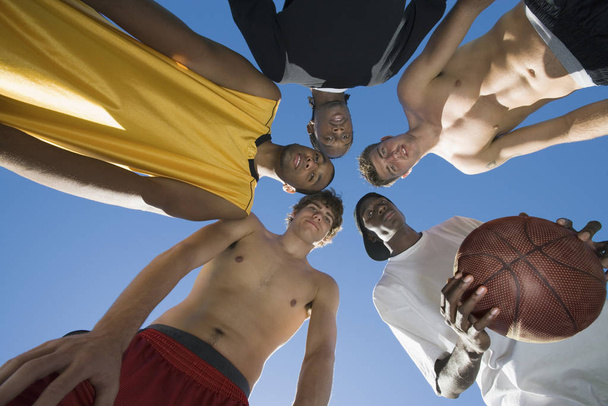 Low angle view of multiethnic group of friends with basketball - Foto, Bild