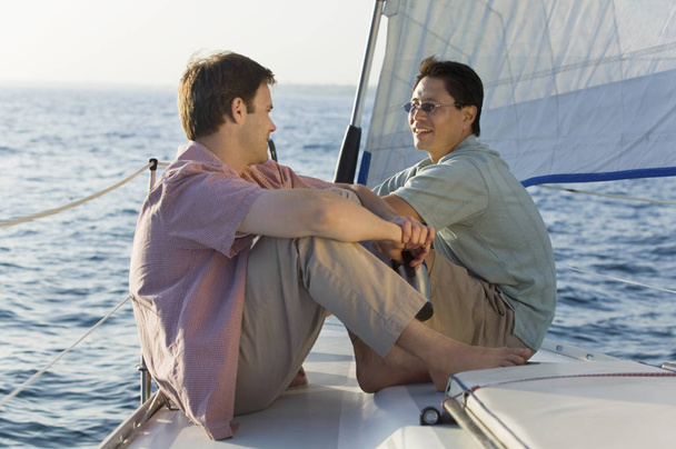 Two mature men having a friendly chat on the yacht during vacation - Foto, Imagem