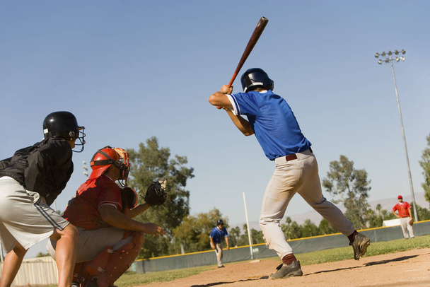 Attaccante da baseball pronto per un tiro con portiere e arbitro in posizione
 - Foto, immagini