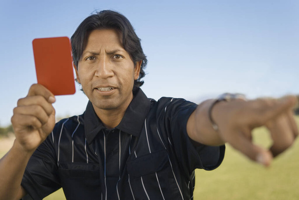 Portrait of a referee indicating dismissal of a player holding red card - Фото, зображення