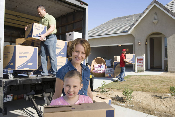Happy family with cardboard boxes moving into new house - 写真・画像