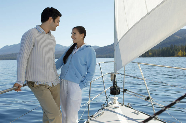 Happy couple looking at each other while standing in a sailboat - Φωτογραφία, εικόνα