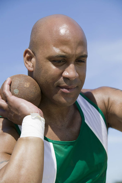 African American male shot putter ready to throw metal ball - Foto, imagen