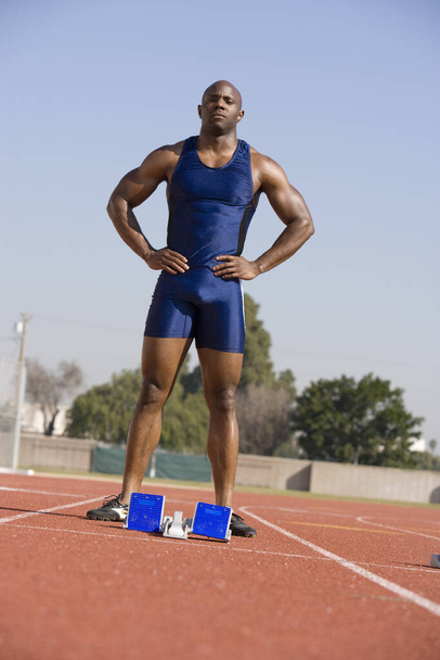 Full length of African American male athlete at starting block on race track - Φωτογραφία, εικόνα
