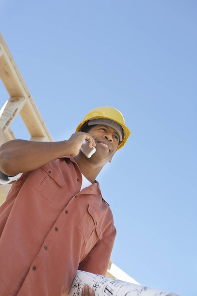 Low angle view of an African American contractor using cell phone - Fotoğraf, Görsel