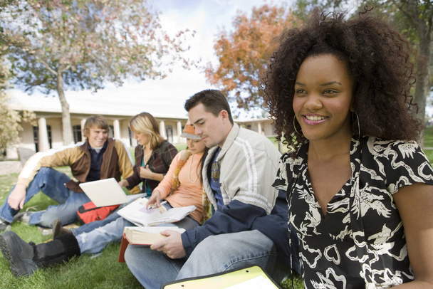 Young African American woman with friends studying at college campus - 写真・画像