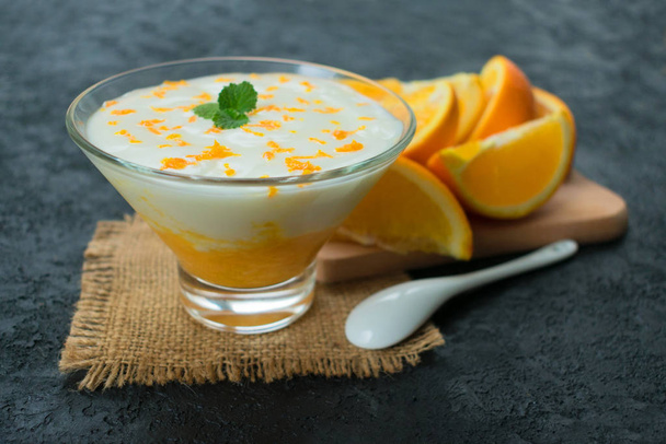  Virkistävä jogurtti jälkiruoka oranssi smoothie mustalla pohjalla
. - Valokuva, kuva