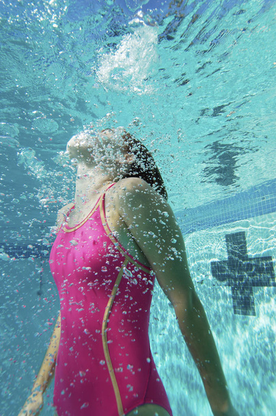 Young Caucasian female swimmer swimming underwater - Foto, imagen