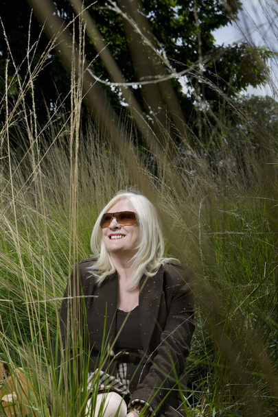 Woman Sitting in Tall Grass - Foto, imagen