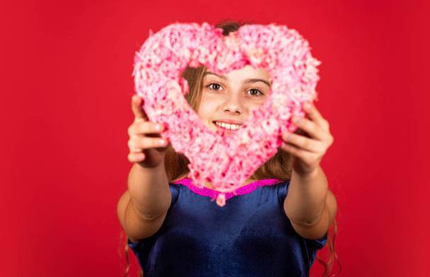 Heart shaped decor valentines day. Feeling loved. Lovely baby. Adorable girl having fun. Romantic mood. Happy child hold heart red background. Holiday of love and care. Little girl with pink heart - Valokuva, kuva