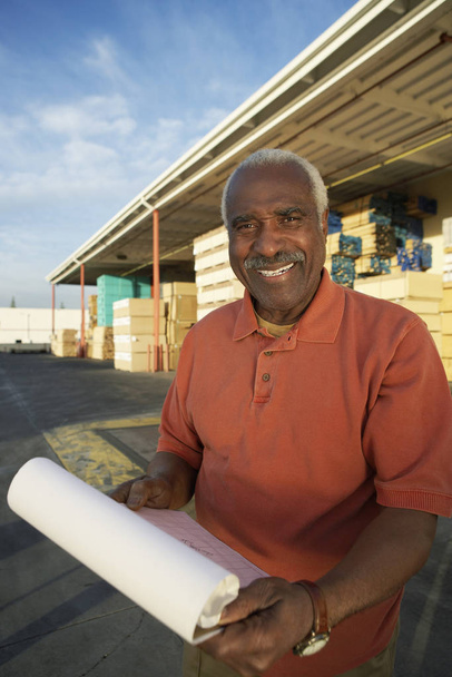 Portrait of a senior warehouse worker holding clipboard - Zdjęcie, obraz