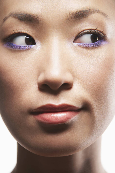 Closeup of woman with purple eyeliner looking sideways - Foto, Imagem