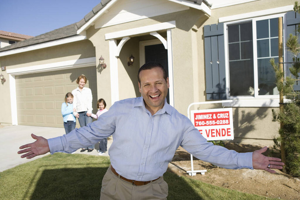 Portrait of excited man with family standing in front of house for sale - Photo, Image