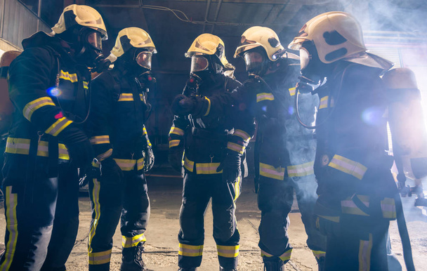 Portrait d'un groupe de pompiers au milieu de la fumée de l'extincteur - Photo, image