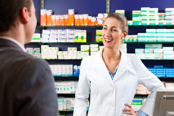 Female pharmacist consulting a customer in pharmacy - Foto, Imagem
