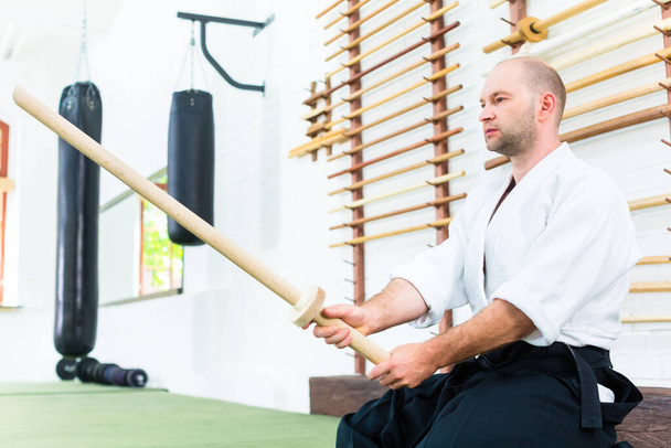 Man at Aikido martial arts with wooden sword - Fotó, kép
