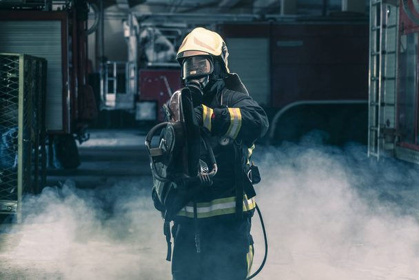 Portrait of a firefighter wearing full protective equipment posi - Photo, Image