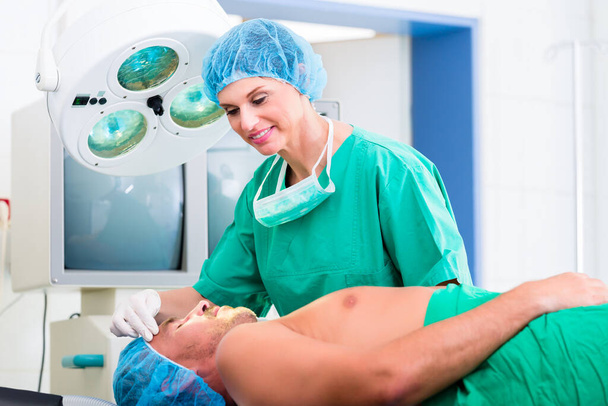 Orthopedic surgeon doctor operating patient in surgery or hospital - Foto, Imagen