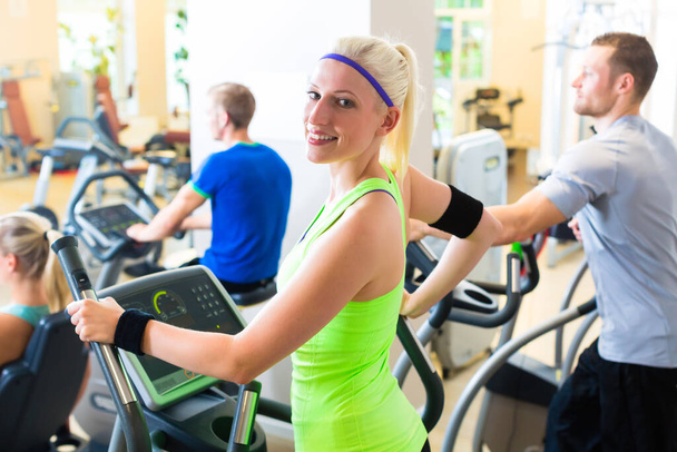 Group in gym on elliptical trainer - Photo, Image