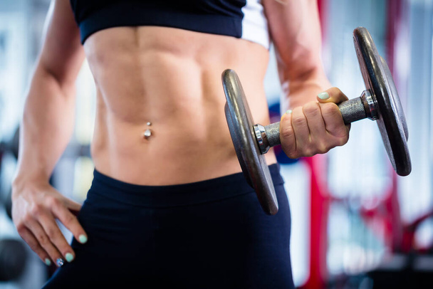 Bodybuilder woman lifting weights in fitness gym - Фото, зображення
