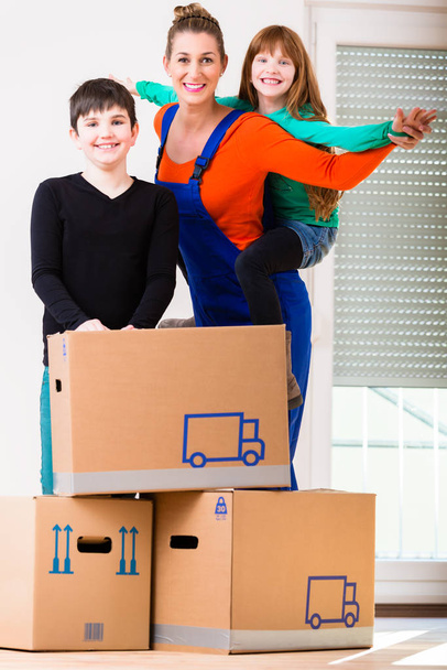 Mother with kids moving in new house or home - 写真・画像