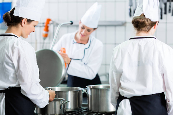 Commercial kitchen with chefs cooking - Foto, Bild