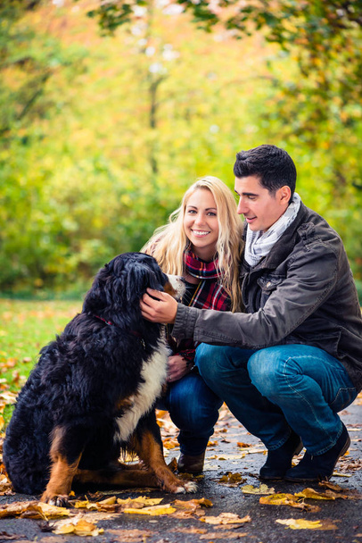 Couple with dog enjoying autumn in nature - Foto, imagen