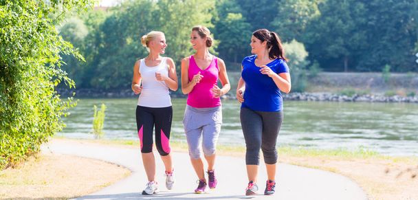 Group of women running at lakeside jogging - Fotoğraf, Görsel