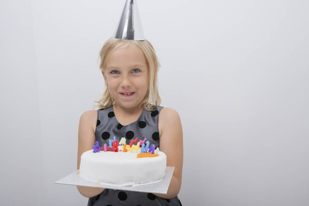 Portrait of happy girl holding birthday cake at home - Fotó, kép