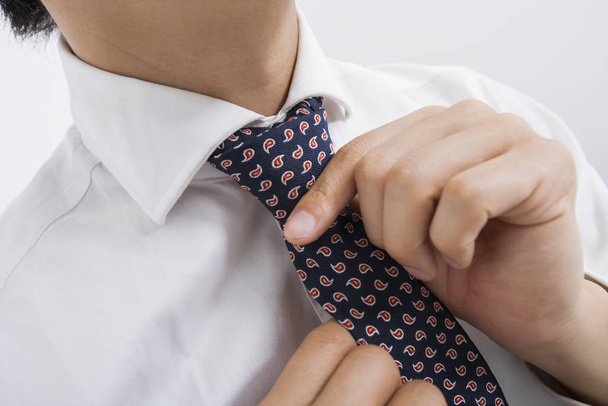 Midsection of mid adult businessman adjusting tie - Foto, Imagen