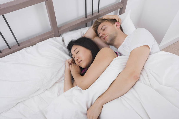Multiethnic couple resting in bed - Foto, imagen
