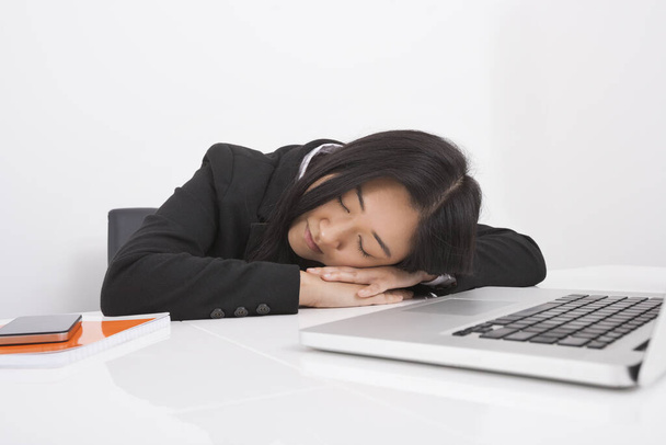 Exhausted businesswoman resting at office desk - Foto, afbeelding