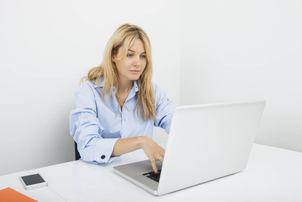 Jovem empresária usando laptop na mesa no escritório - Foto, Imagem