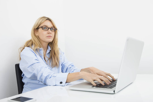 Nachdenkliche Geschäftsfrau mit Laptop im Büro - Foto, Bild