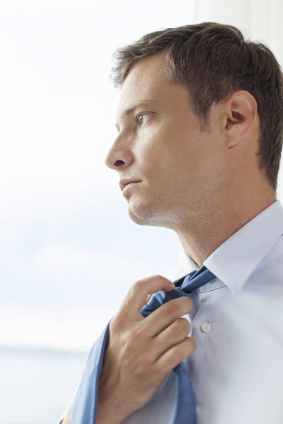 Close-up of pensive businessman loosening necktie in hotel - Фото, зображення
